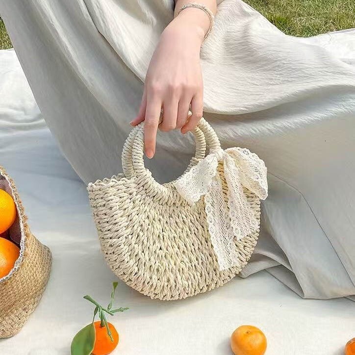 New spring and summer niche semi-circular grass woven leisure vacation style beach bag designer women's hand-held crossbody bag hollowed out tren