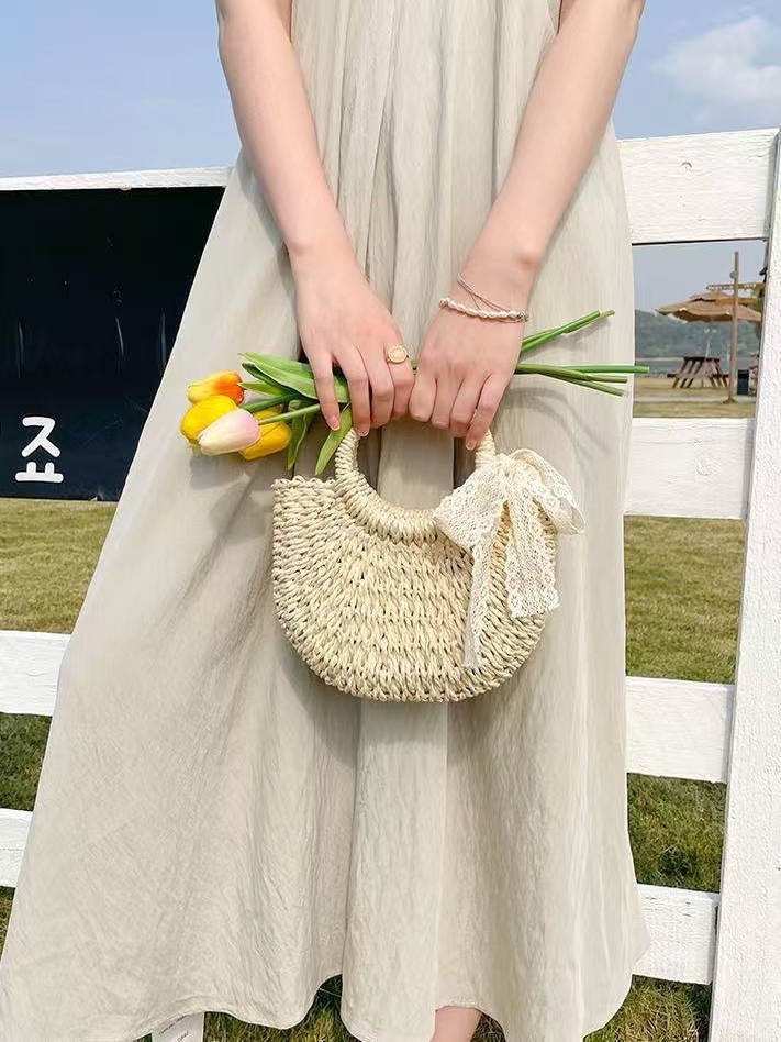 New spring and summer niche semi-circular grass woven leisure vacation style beach bag designer women's hand-held crossbody bag hollowed out tren