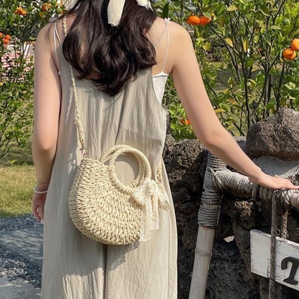 New spring and summer niche semi-circular grass woven leisure vacation style beach bag designer women's hand-held crossbody bag hollowed out tren