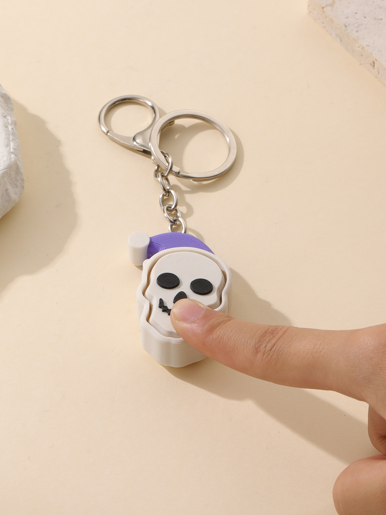 3D printed Christmas hat skull keychain - adult stress relief toy, with a portable anxiety relief gadget featuring a clickable keyboard design