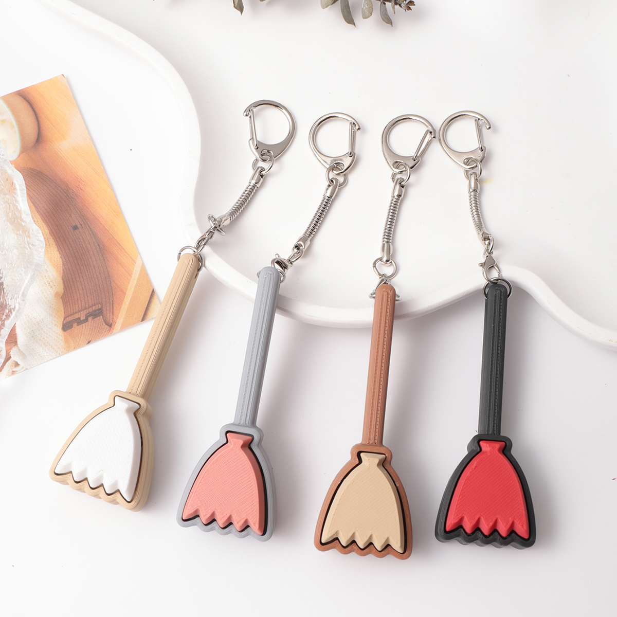 3D printed broom-shaped keychain - an adult stress relief toy with a portable anxiety relief gadget featuring a clickable keyboard design