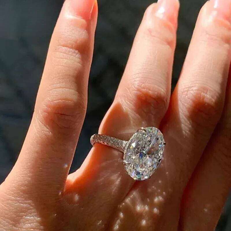 3. A 14K white gold ring weighing 4 grams, featuring oval moissanite gemstones set in diamonds. It is a men's wedding ring, with a classic and fa