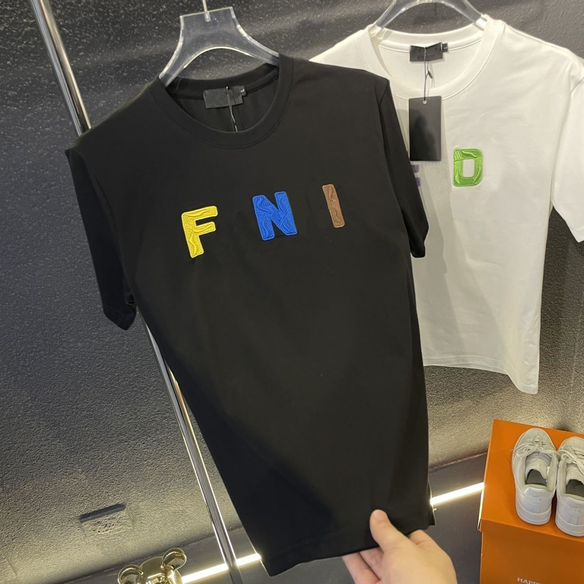 Men's T-shirts from designer brands are fashionable summer garments. These T-shirts, with their washed letter patterns, showcase a casual street style.