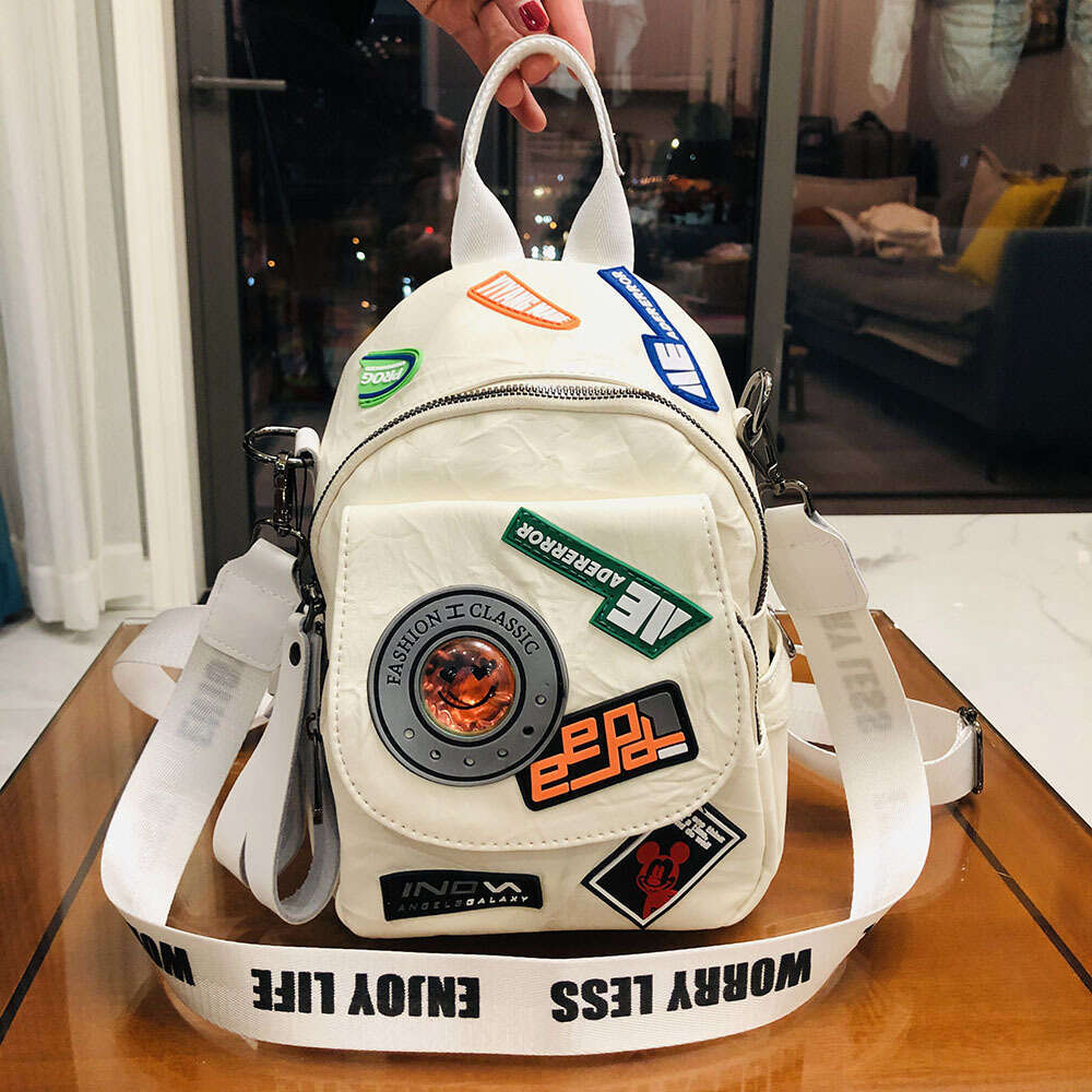 Backpack for girls with Japanese and Korean style pleated high aesthetic badge design, trendy casual shoulder bag