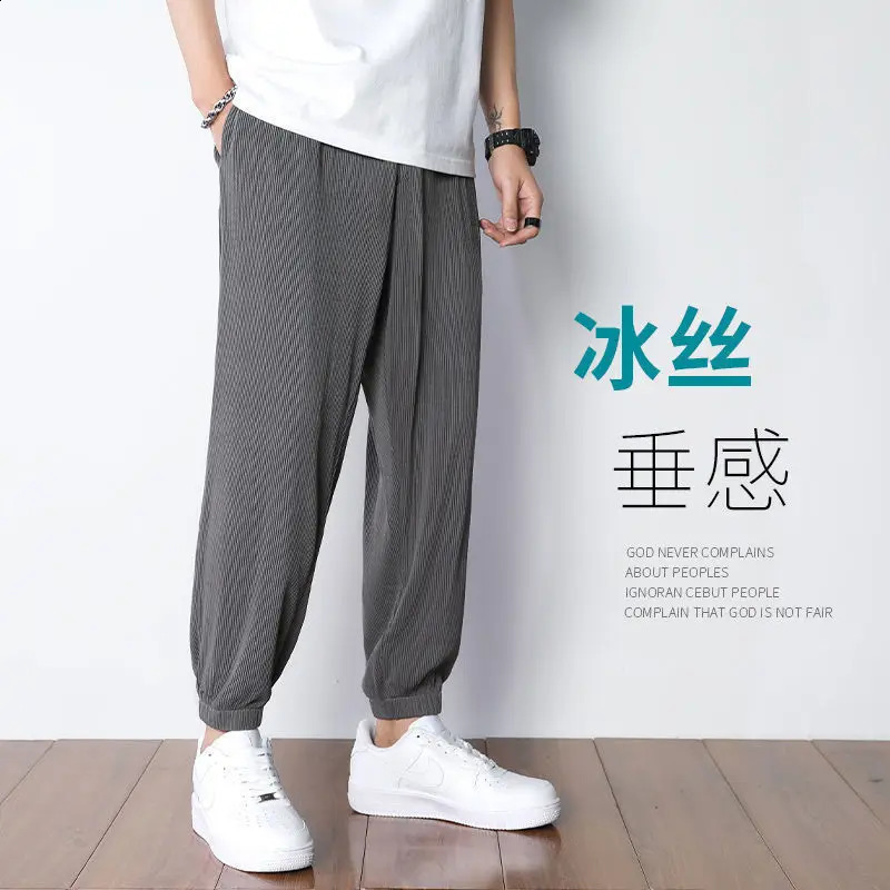 Ice silk pants for men in summer thin and loose with a light beam and drooping feet. Quick drying and casual mens Trouser trend. Nine oclock harem spo