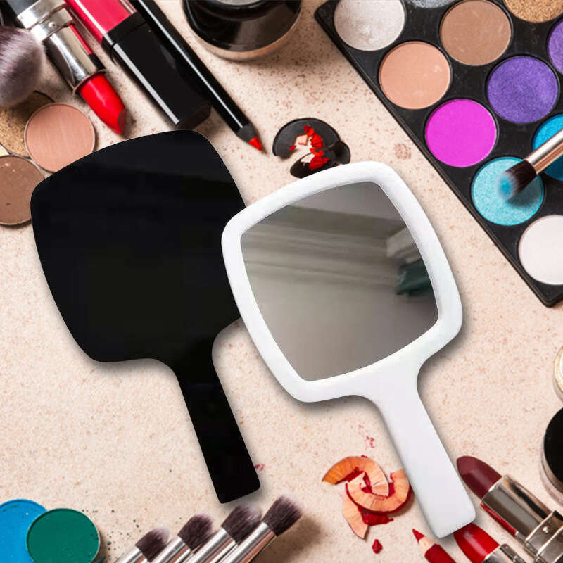 Designer holding black and white classic style women's travel portable small mirror essential makeup