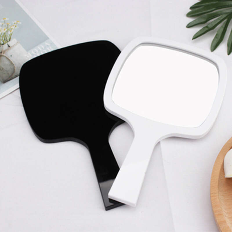 Designer holding black and white classic style women's travel portable small mirror essential makeup