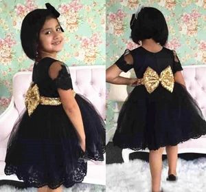 Vestido de fiesta corto negro para niñas Cinturón con lazo dorado Manga corta Una línea Encantador nuevo diseño Vestidos para niñas Tamaño personalizado