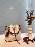Designer Utsökt liten hinkväska Unik perforerad ihålig designstil Enkelt axelkors Slung med en plånboks handväska praktisk
