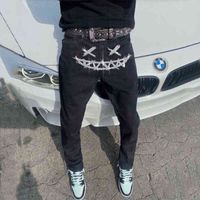 Homem de strass orifícios de jeapis de jeans masculinos de jeans pretos elásticos e magros fit