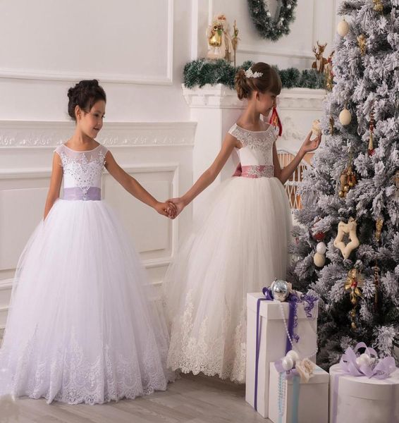 2015 Vestidos de niña de flores de Tulle Apliques de cuentas transparentes Vestidos de baile de Navidad para boda Bows Bows encantadores personalizados M1638480