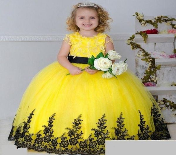 2016 Nuevos vestidos de niña de flores de encaje de tul amarillo para boda Cuello redondo Sin mangas Apliques negros Sash Bow Vestidos largos para niñas B1962666