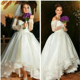 2018 Vestidos de novia cortos árabes de longitud de té Fuera de los hombros Mangas largas transparentes Apliques Niveles Volantes Vestidos de novia de boda