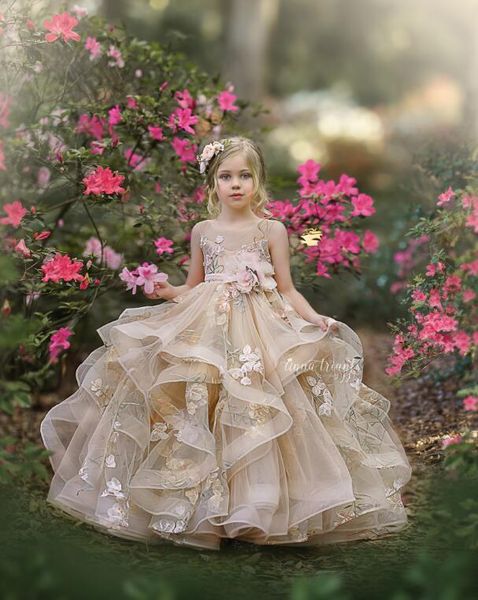 2021 Lindos vestidos de niña de las flores de champán para bodas Cuello de joya Volantes hinchados Con gradas Floral Niños pequeños Vestidos de bebé Vestido de primera comunión con lazo Espalda abierta