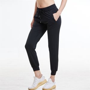 2020 Mujeres Telas elásticas Ajuste suelto Deporte Leggings ajustados activos con dos bolsillos laterales Pantalones hasta el tobillo LJ200813