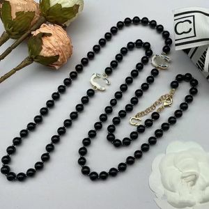 2023 nouveau collier d'automne et d'hiver dans la longue chaîne de pull de luxe multicouche de perles noir et blanc collier long lettre de marque de haute qualité