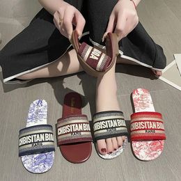Luxurys diseñadores sandalias de calidad superior para mujeres zapatillas de moda correa clásica lienzo de cuero plano letra chanclas de goma fondos zapatos de playa mocasines