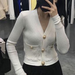 black sweater with gold buttons on sleeves