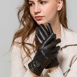 designer leather Mittens Haining women's sheepskin gloves, showing thin, trimmed hands, plush, warm ears of wheat bow