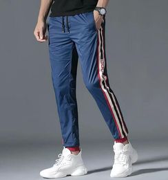 2021 Calça masculina respirável nova calça esportiva com cordão para corrida masculina moda de rua listrada lateral calça casual M-5XL