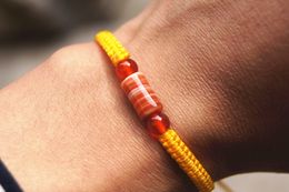 The yellow flat knot manually + cylindrical sardonyx beads lucky bracelet