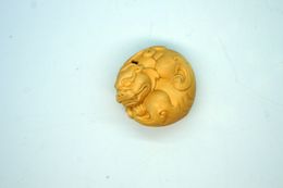 The yellow poplar wood is hand-carved and decorated with a single - mythical creature (round). Talisman necklace pendant.