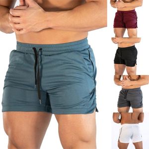 男性の固体弾性ウエストのトレーニングのトレーニングショートパンツ巾着スポーツのカジュアルなフィットネスショートパンツを使って汗をかいているズボン