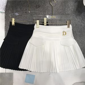 Preppy Style White Breattable Pleated A Line Dance Mini kjolar Kvinnor Ny vår sommaren hög midja fick sömnad puffy kort kjol