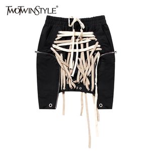 TWOTWINSTYLE Sexy Bandage Frauen Rock Hohe Taille Patchwork Hit Farbe Asymmetrische Kurze Mini Röcke Weibliche Mode Kleidung Flut 210309