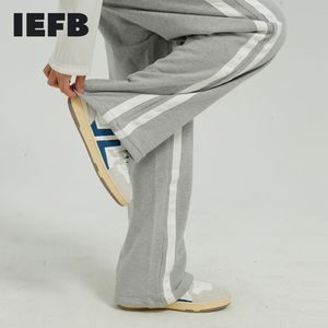 IEFB Mäns Slitage Vår Koreanska Streetwear Mode Side Striped Patchwork Loose Casual Pants Elastic Midja Rakbyxor 210524