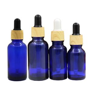 Garrafa de óleo essencial de vidro azul vazio Falso madeira de anel de madeira de plástico 5ml 10ml 15ml 20ml 30ml 50ml 100ml Embalagem de embalagem de borracha contêineres