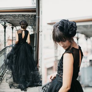 Schwarzes Gothic-Hochzeitskleid in A-Linie mit Paspelierung, mehrstufiger Tüllrock, Spitzenapplikationen, Schlüsselloch-Rückseite, individuelle Rüschen, Juwelenausschnitt, Vintage, einzigartige, rustikale Land-Brautkleider