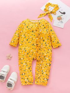 아기 소녀의 작은 꽃 패턴이 웅크 리고 jumpsuit와 머리 밴드 그녀를