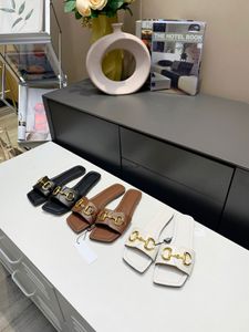 Le pantofole peep-toe con diapositive in pelle sono decorate con gli accessori firmati con fibbia a cavallo del marchio Design allungato a doppio anello attraversato