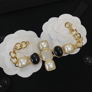 Bracciale con ciondolo a croce con perle bianche e nere alla moda vintage, nome famoso, marchio di gioielli