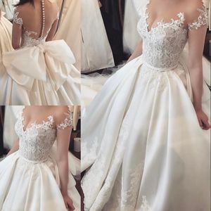 Klassisk Romantik Satin Bröllop Klänning Sheer Jewel Kortärmad Lace Applique Big Bow Bröllopsklänningar Sexig Se genom Backless Bröllopsklänning