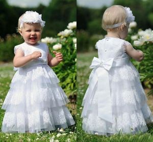 Schönes Design, weiße Spitze, Blumenmädchenkleid für Hochzeit, Schleife, Gürtel, Stufenrock, A-Linie, Kleinkind-Erstkommunion-Kleider nach Maß