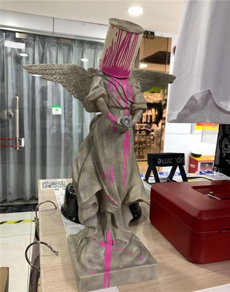 

banksy iron bucket angel splashing paint angel sculpture