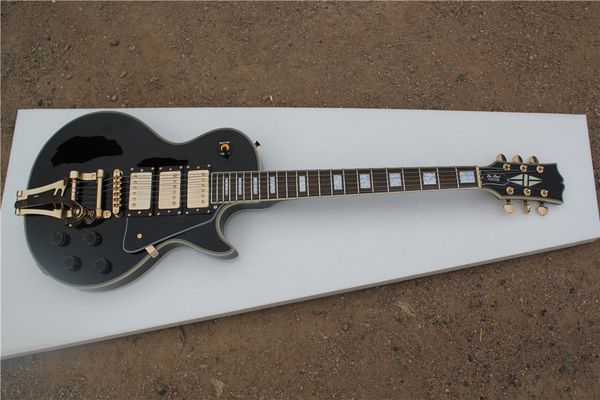 

black electric guitar mahogany body cream bound rosewood fingerboard big tremolo rocker fixed bridge gold knob