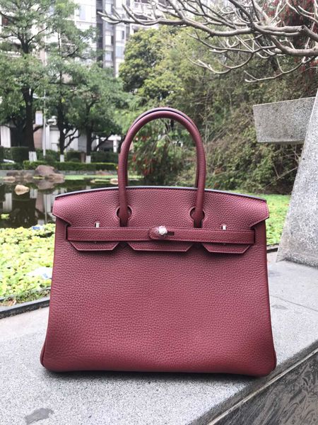 

wholesale fully handmade burgundy togo leather design purse 30cm,wax thread, have both gold and silver hardware,contact me for details