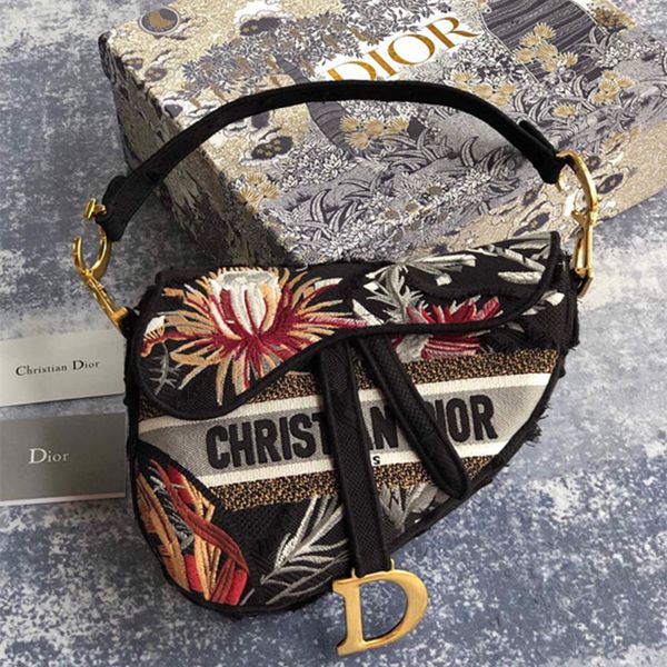 

this mid-sized saddle bag features a floral print inspired by a wild garden with black material and tassels to give it a camouflaged look