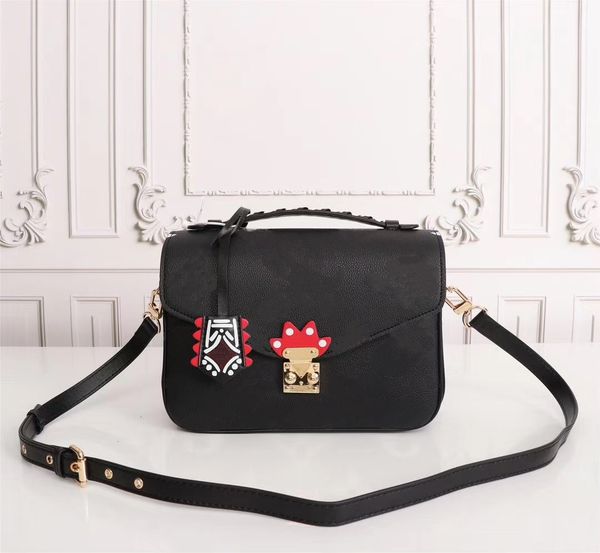 

crafty pochette mÃ©tis embossed leather extra-large print letters braided handle graffiti inspired charm shoulder crossbody bag