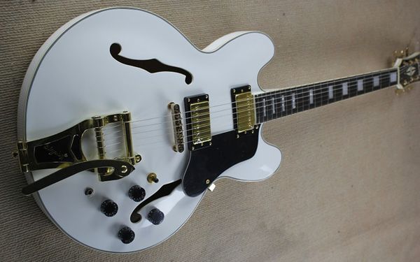 

white jazz thin body semi-hollow electric guitar with large rocker tremolo system
