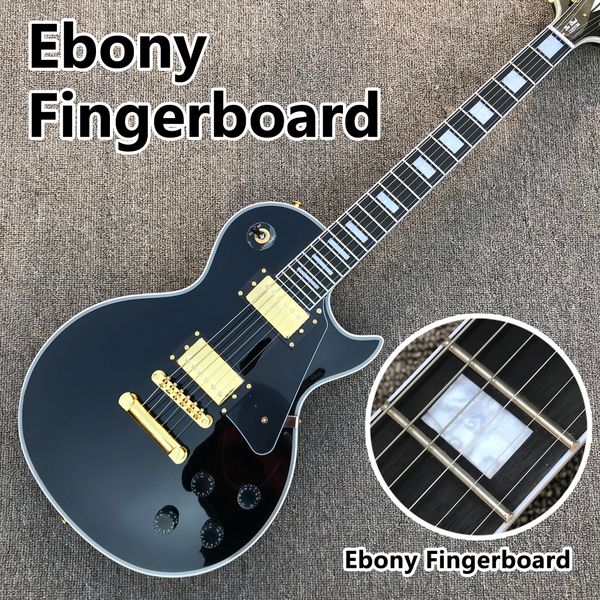 

black electric guitar, ebony fingerboard, gold hardware, solid mahogany body