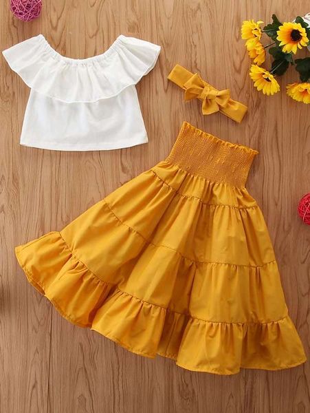 

little girl's ruffled shirt and pleated skirt and hair band she, White