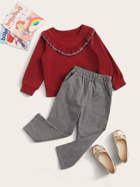 

little girl's ruffle sweatshirt and checked pants she, White