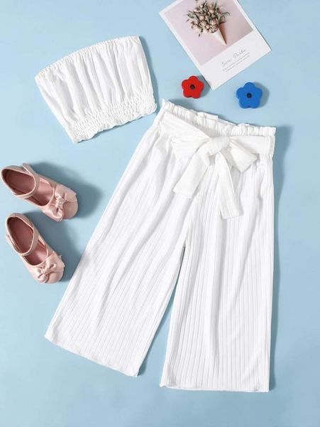 

the little girl has a pleated rag a belt and paper bag pants she, White