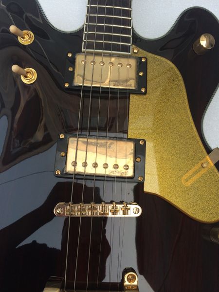 

black electric guitar bridge tremolo gold hardware