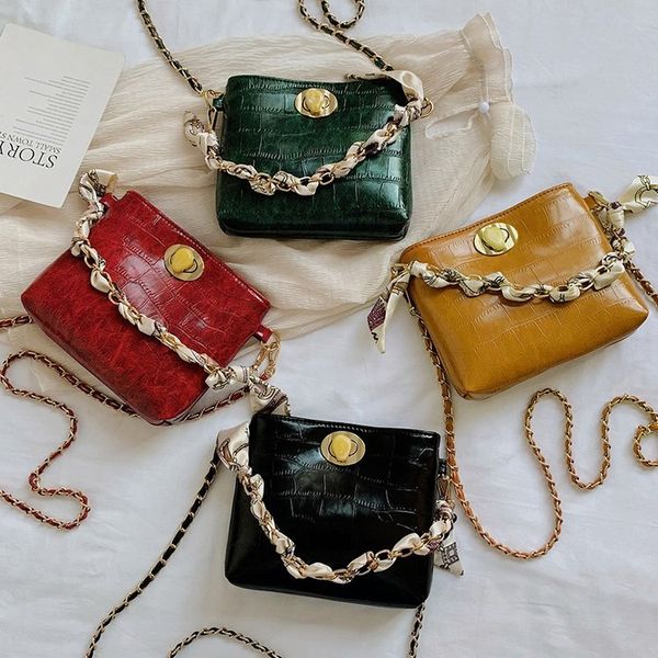 дизайнер-бриллиантовая цепочка перекинута через одно плечо небольшой квадратной сумкой женщины