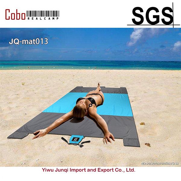 

beach blanket 7' x 9' oversized sand proof picnic mat for traveling hiking camping and festivals with 4 stakes 4 corner pockets
